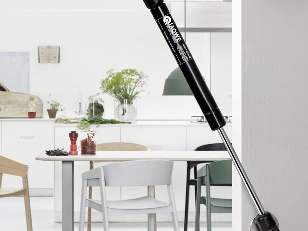 An IAQWE gas strut holding a kitchen cabinet flip-up door open